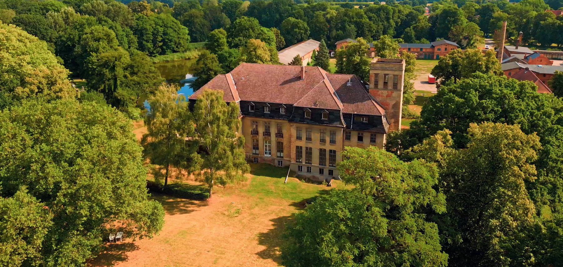 The house from the air, the pond to the left, the park all around