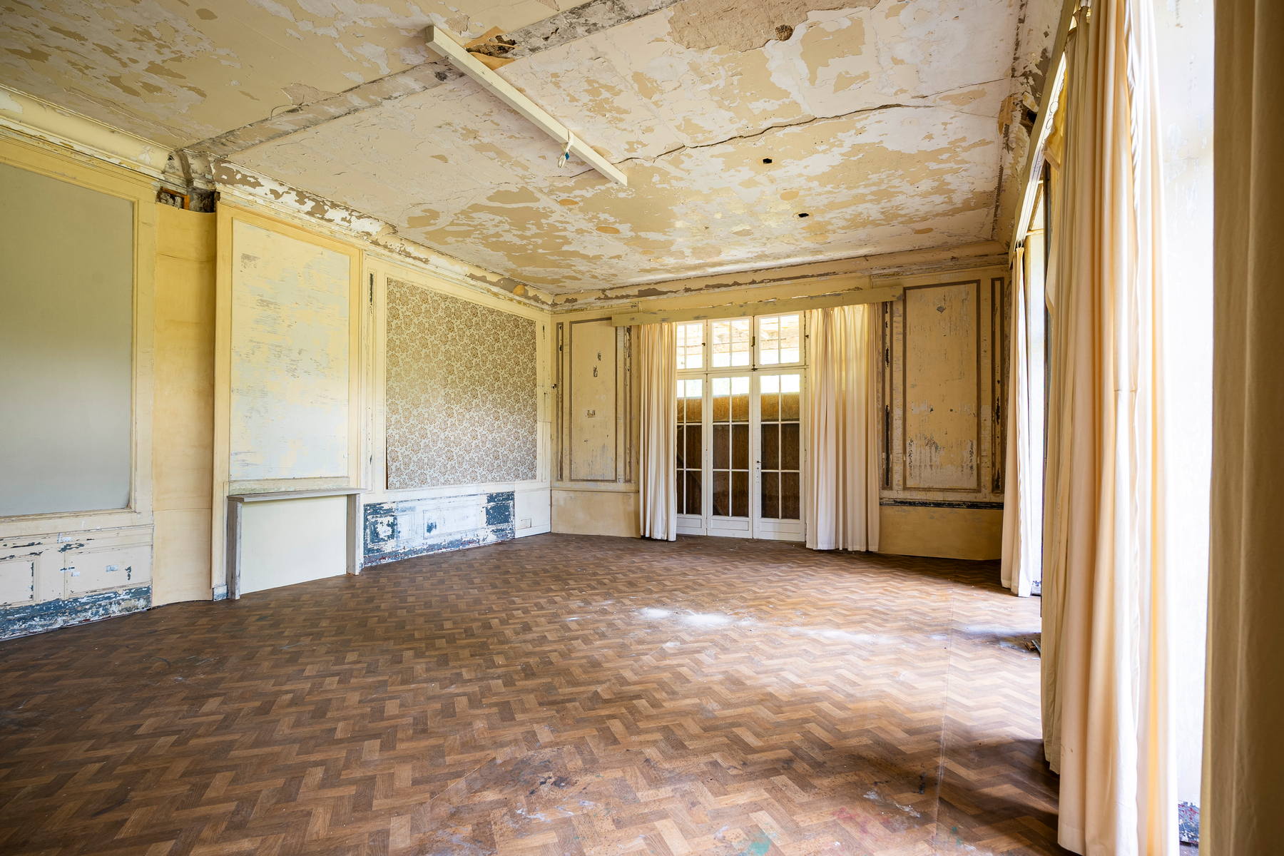 An unrestored hall with herringbone parquet